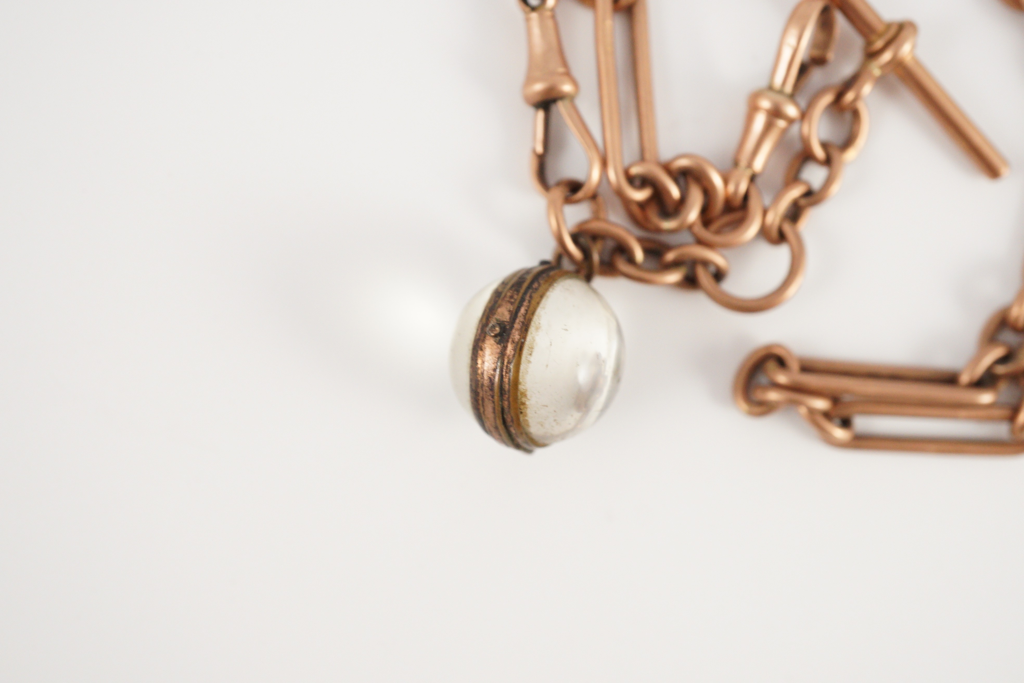 An early 20th century 9ct gold albert with magnified lens fob
